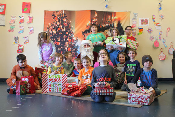 Students in an autism support program gather around Santa at their special needs school