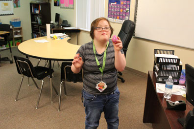 A high school student shows off a toy she is using in her special education classroom