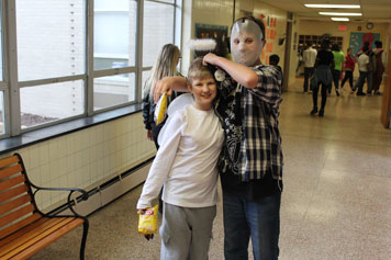 Two young boys show off their costumes in the hallway as their special education school prepares for Halloween
