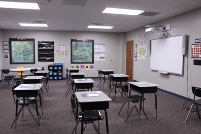 Empty desks face a smart board in an emotional support classroom at a special needs school