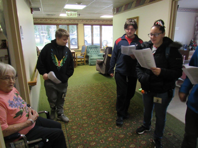 Members of an emotional support class visit with residents of an assisted living home during a field trip