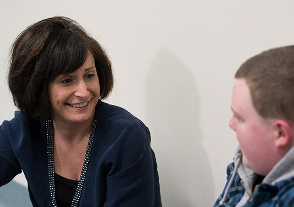 Smiling counselor providing emotional support to a student at a special education school.