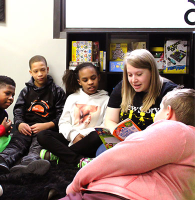 A special education teacher reads to a large group of students in her classroom.