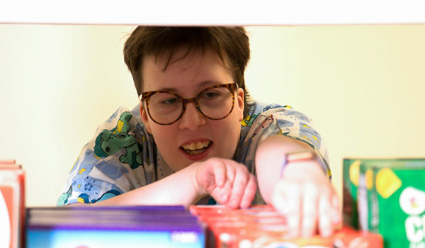 Special education teen girl, in the Transition program, stocking shelves as part of developing life skills.