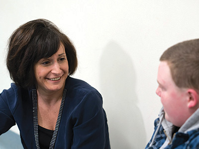 Smiling counselor providing emotional support to a student at a special education school.