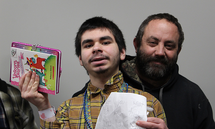 Father and Son at the book fair. Son holds up his book titled, "The Adventures of Unicorn."