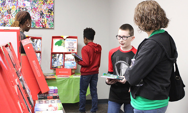 Two mother and son pairs peruse the book fair. 