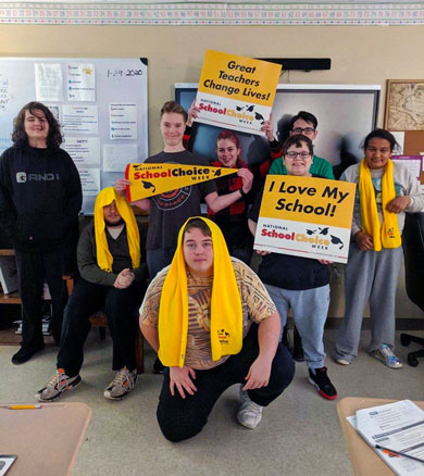 A group of special needs students wear yellow and smile as they celebrate school choice week.