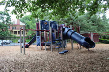 A blue slide and playground equipment stand ready outside a special needs school