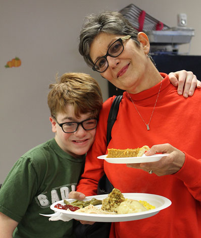 An elementary school boy in an emotional support program smiles with his special education teacher 