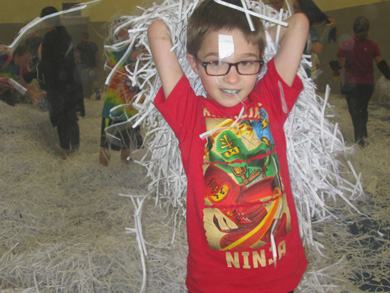 A special education students plays with shreds of papers during an event at his school