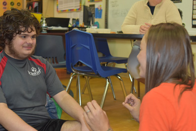 A boy smiles at his special education teacher during a lesson