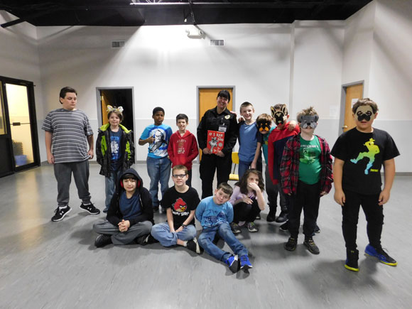 A special education classroom poses while some students wear animal masks