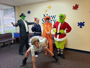 A group of special education teachers show off costumes in the lobby of their school