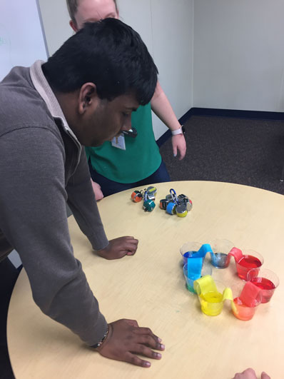 A special education student leans over a STEAM project to watch its progress