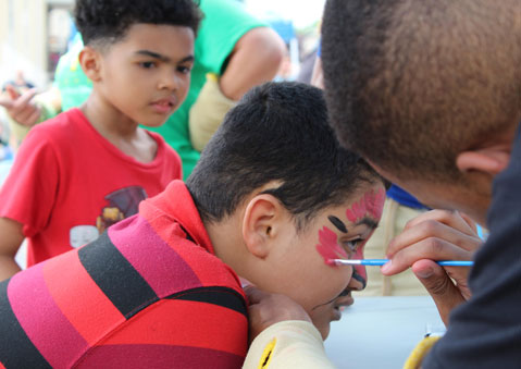 A special education student gets his face painted at an event at his high school 