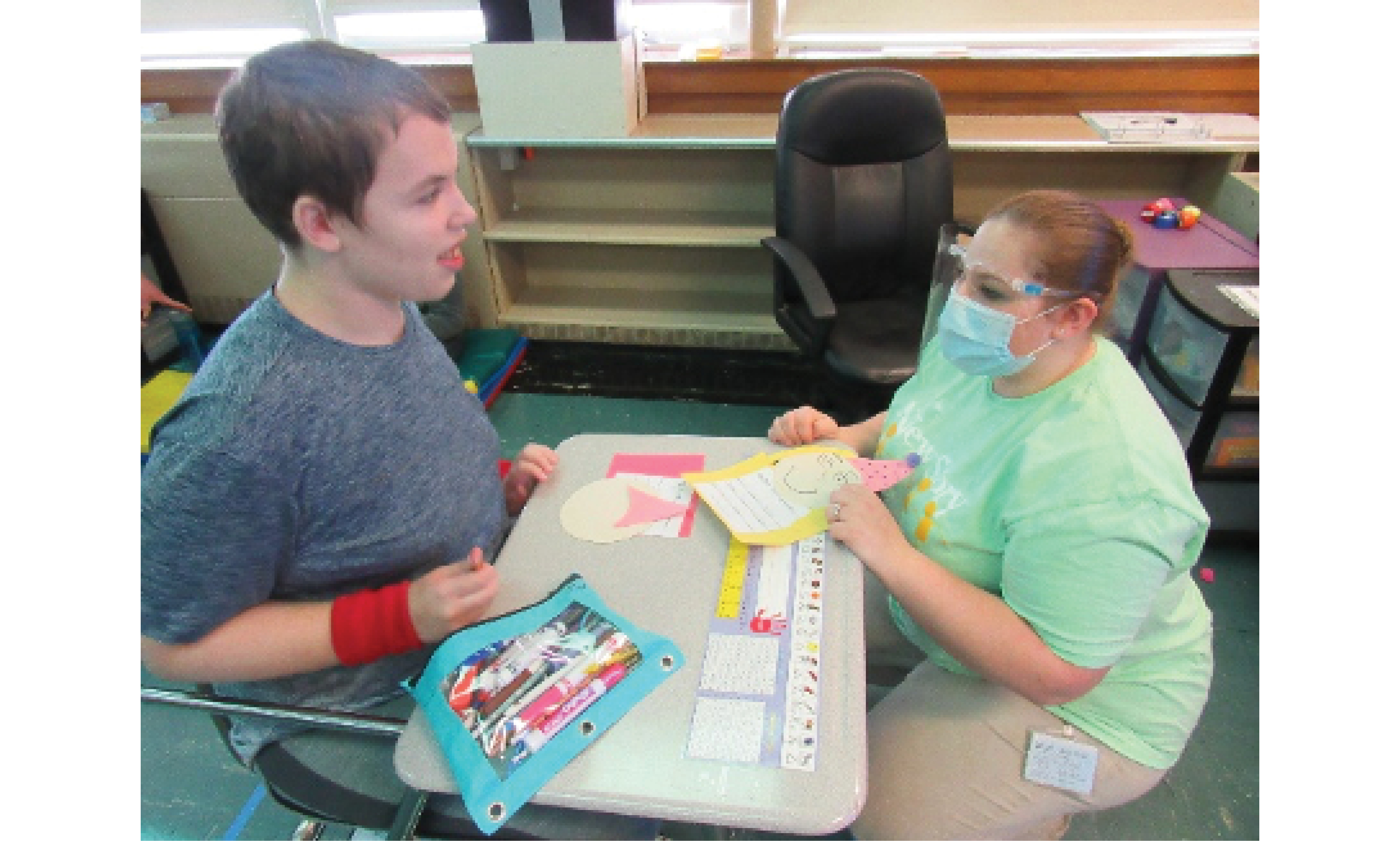 Student and Teacher work on New Year's Resolutions craft together