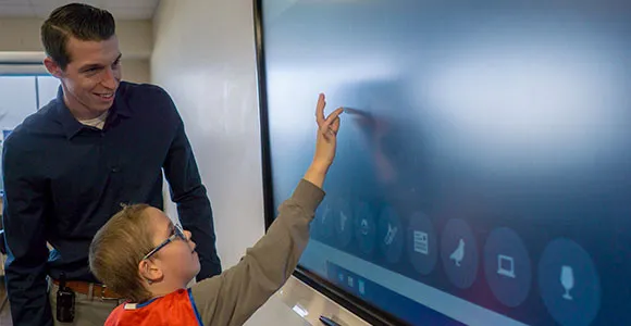 Elementary student in autism support program interacts with smart board in special education school