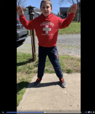 Student does jumping jacks outside.